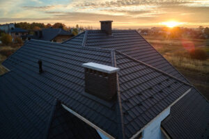 A metal roof featuring a chimney and chimney stack, showcasing the work of a metal roof installer.
