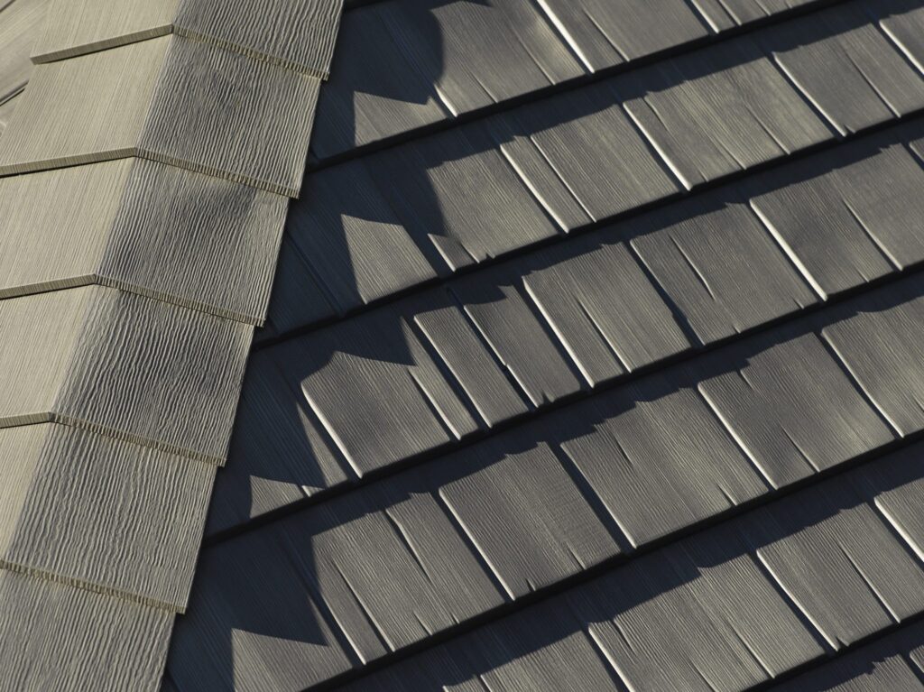 Close-up of a gray metal shingled roof, showcasing the texture and pattern of the shingles.