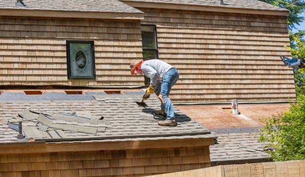 A man is re-roofing a house, working carefully on the roof to ensure proper installation and safety.