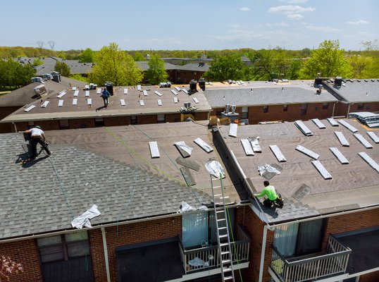 aerial view of exterior construction and roofing services being done on a house.
