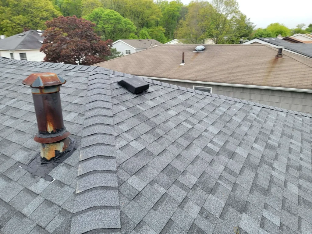 A newly done roofing services in New York showing exterior part of a chimney as well.