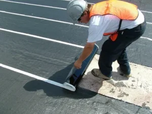 Contractor applying a protective membrane layer on a concrete surface during a commercial Waterproofing project
